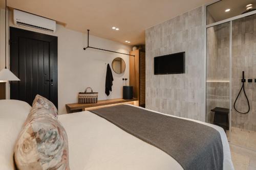 a bedroom with a bed and a tv on a wall at Emery Hotel in Naxos Chora