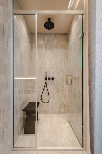 a shower with a glass door in a bathroom at Emery Hotel in Naxos Chora