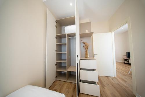 a bedroom with white walls and white shelves at Face à la Baie, Vue Panoramique in LʼAgha