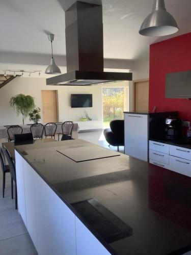 une cuisine avec des armoires blanches et un comptoir noir dans l'établissement Gîte Milandré, à Banassac