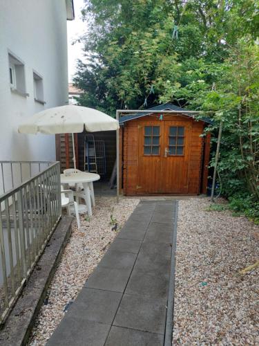 a patio with a table and an umbrella and a building at 2-Zimmerwohnung, 80qm mit Terrasse und großem Garten bei Frankfurt am Main in Bad Vilbel