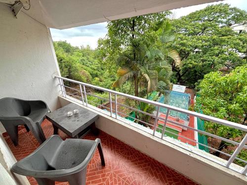 a balcony with a desk and a chair and a table at Yugandhar holiday home in Lonavala