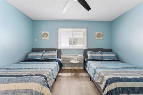 two beds in a room with blue walls at 301 Ocean Ave, Unit 206 - The Harbor Light in North Wildwood