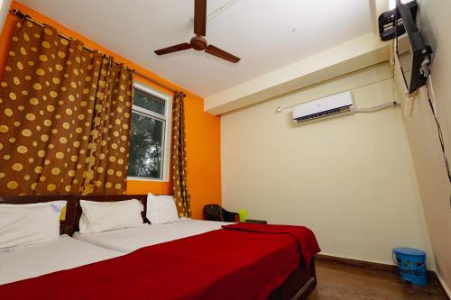 a bedroom with a bed with a red blanket and a window at Pvt Residency in Palni