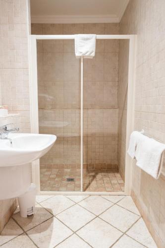 a bathroom with a shower with a sink and a toilet at Hotel Arena le Refuge in Corte