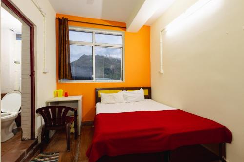 a small bedroom with a red bed and a window at Pvt Residency in Palni