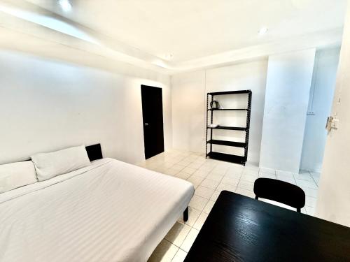 a bedroom with a white bed and a black table at Patong Canal Villa R105 in Patong Beach