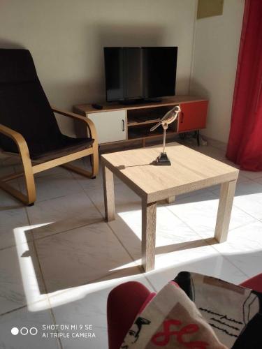 un salon avec une table basse et une télévision dans l'établissement A quelques pas de la mer, à Saint Cyprien Plage