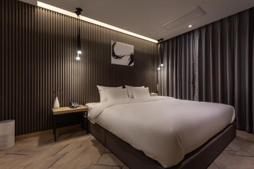 1 dormitorio con 1 cama grande y mesa auxiliar en 21 Heritage Hotel, en Wonju
