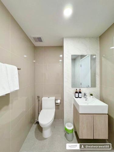 a bathroom with a white toilet and a sink at อีสต์วิลล์บางแสน36 in Ban Hua Khao Sammuk