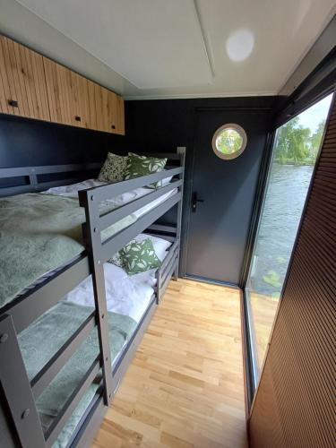 a room with bunk beds in a tiny house at Pływający Apartament in Augustów