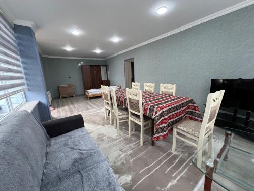a dining room with a table and chairs and a couch at Qoşa bulaq in Avaxıl