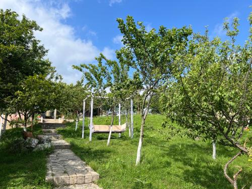 a park with a swing in the grass with trees at Qoşa bulaq in Avaxıl