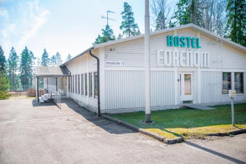 a white building with a sign on the side of it at Forenom Hostel Vantaa Aviapolis in Vantaa
