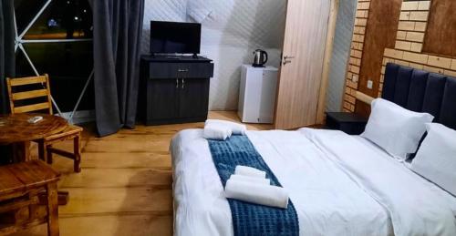 a bedroom with a bed and a table and a television at Loreni Garden in Getahovit