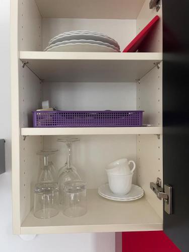 a white cabinet with dishes and plates on it at WHLIVING - Apartments & Studios in Konstanz in Konstanz