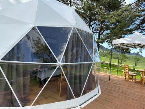 an igloo with a table and an umbrella on a deck at Loreni Garden in Getahovit
