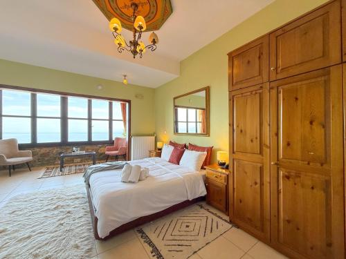 a bedroom with a large bed with a large wooden cabinet at Pliades Traditional Guesthouse in Palaios Panteleimon