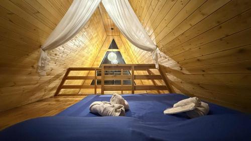a bedroom with a blue bed in a tree house at Oda Riverside Cottages in Aragvispiri