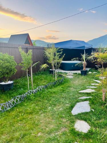 a garden with trees and a fence and a boat at Oda Riverside Cottages in Aragvispiri