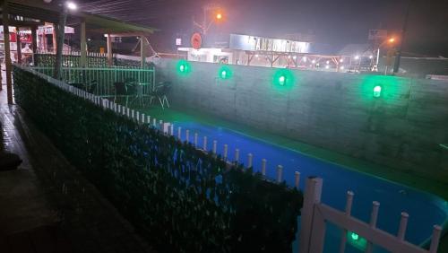 a swimming pool at night with green lights at Pousada Ilha do Itacolomi Com Piscina Proximo do Beto Carrero in Penha