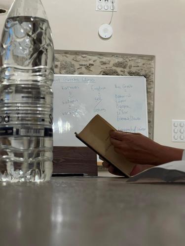 a person reading a book next to a bottle of water at Katharsis Palace 15th Century Art Hotel at Naxos Old Town II in Naxos Chora