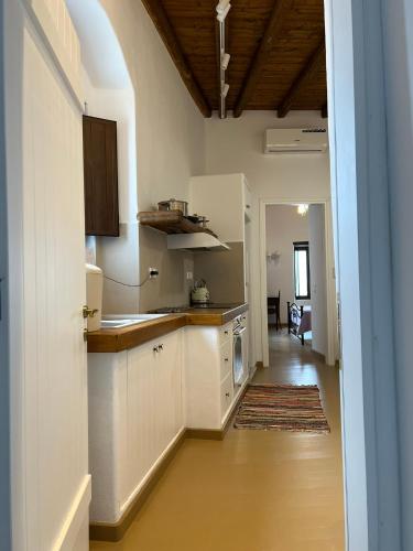 a kitchen with white cabinets and a hallway at Katharsis Palace 15th Century Art Hotel at Naxos Old Town II in Naxos Chora