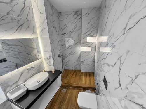 a white bathroom with a sink and a toilet at Katharsis Palace 15th Century Art Hotel at Naxos Old Town II in Naxos Chora