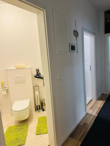 a bathroom with a toilet and yellow rugs at Cocoon City in Stuttgart