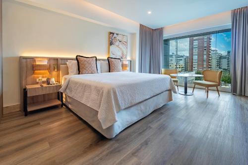a hotel room with a large bed and a view of a city at Holiday Inn Santo Domingo by IHG in Santo Domingo