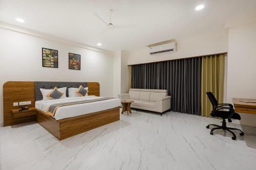 a bedroom with a bed and a couch and a desk at Lemonridge Hotels IDPL Balanagar in Hyderabad