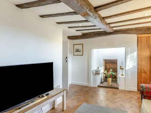 a living room with a large flat screen tv at Malting Cottage in Much Hadham