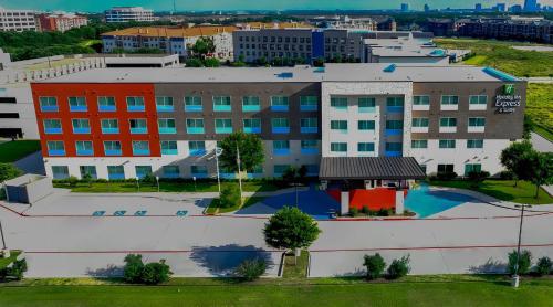 an aerial view of a building with a pool at Holiday Inn Express & Suites Dallas NW - Farmers Branch by IHG in Farmers Branch