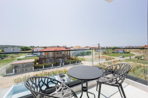 a balcony with a table and chairs and a view at Chalkidiki Suites in Paralia Dionysiou