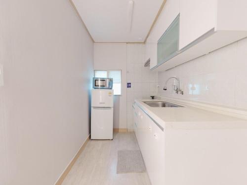 Una cocina blanca con fregadero y refrigerador. en Miso3bedrooms 5beds seoulST, en Seúl