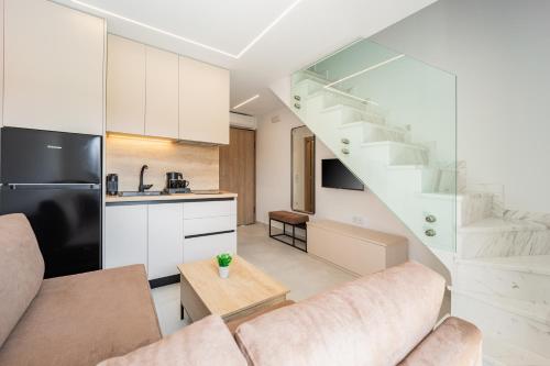 a kitchen and a living room with a staircase at Chalkidiki Suites in Paralia Dionysiou