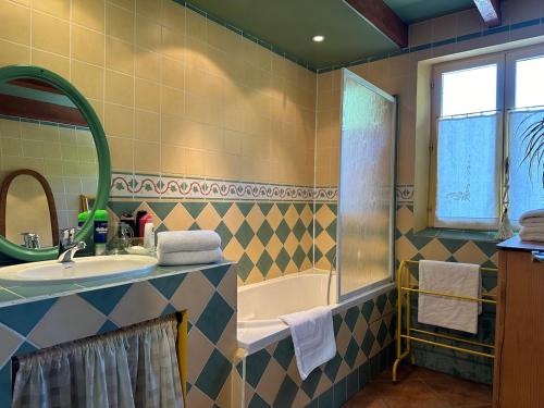 un baño con lavabo y bañera en Beau mas cévenol avec piscine, en Corbés