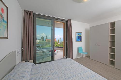 バルドリーノにあるVilla T14のベッドルーム1室(ベッド1台付)、スライド式ガラスドアが備わります。