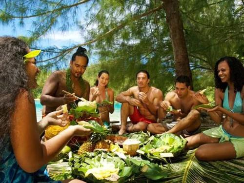 a group of people sitting around a table with food at B & Bee Wild Island - Nature Song in Fare