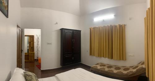 a bedroom with a bed and a closet and a curtain at Anns and Pyarys Homestay in Anniyartholu