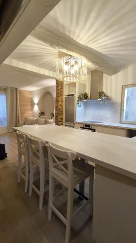 une salle à manger avec une grande table blanche et des chaises dans l'établissement L' Alto - 80m2, Grand Terrasse avec vue sur le Cap, à 200m des plages, à Cassis