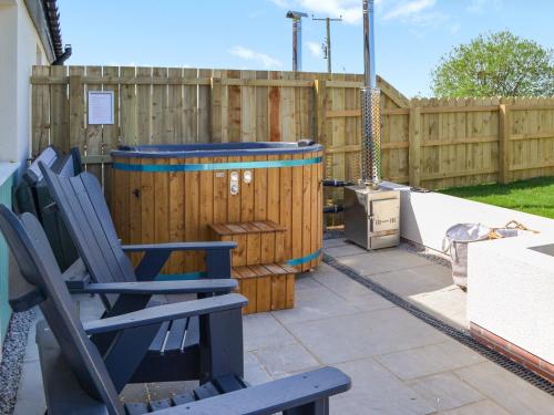 a patio with two chairs and a wooden fence at The Dairy - Uk48756 in Bempton