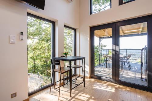 a room with sliding glass doors and a table with a plant at Fácános100 Vendégház in Dunabogdány