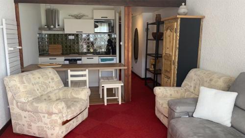 - un salon avec un canapé et une table avec un bureau dans l'établissement Appartement aux pieds des pistes, à Les Deux Alpes