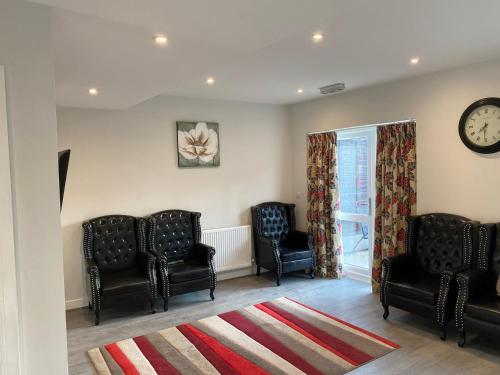 a waiting room with chairs and a clock on the wall at Step4 Home in Rainham