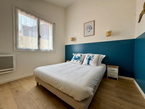 ein Schlafzimmer mit einem großen Bett mit einer blauen Wand in der Unterkunft Évasion Marine à 2 pas du Port in Saint-Gilles-Croix-de-Vie