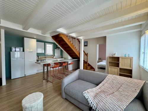 un salon avec un canapé et une cuisine dans l'établissement Évasion Marine à 2 pas du Port, à Saint-Gilles-Croix-de-Vie