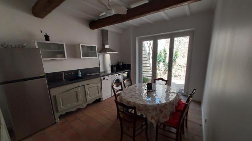 une cuisine avec une table et une cuisine avec une table et des chaises dans l'établissement Renaissance, à Fournès