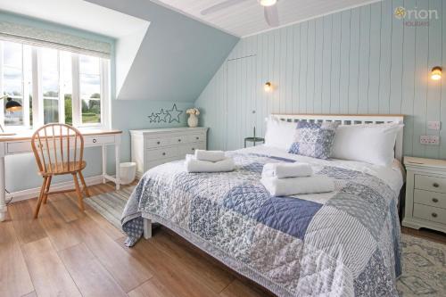 Un dormitorio con una cama, un escritorio y una silla. en Isis Lakes 31, Bonheur, en South Cerney