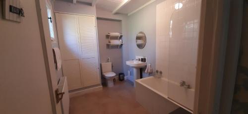 a bathroom with a sink and a toilet and a tub at La Longère du Clos Saint Martin in Cavron-Saint-Martin